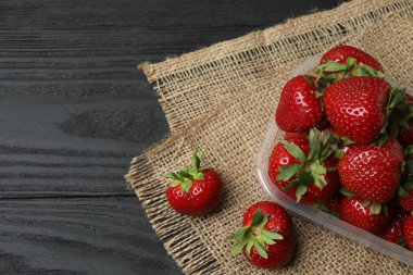 Konteynırdaki ahşap masada çilekler.