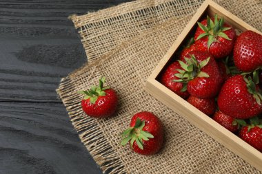 Konteynırdaki ahşap masada çilekler.