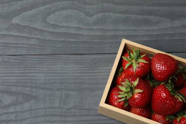 Konteynırdaki ahşap masada çilekler.