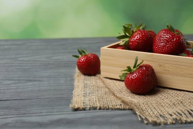 Konteynırdaki ahşap masada çilekler.