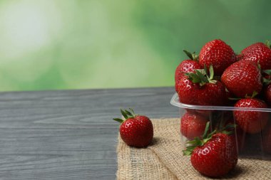 Konteynırdaki ahşap masada çilekler.