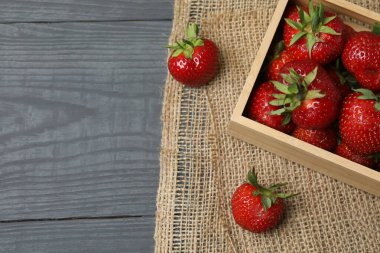 Konteynırdaki ahşap masada çilekler.