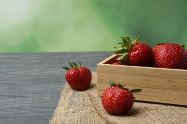 Konteynırdaki ahşap masada çilekler.