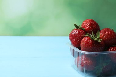 Konteynırdaki ahşap masada çilekler.