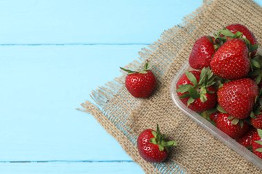 Konteynırdaki ahşap masada çilekler.