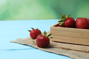 Konteynırdaki ahşap masada çilekler.