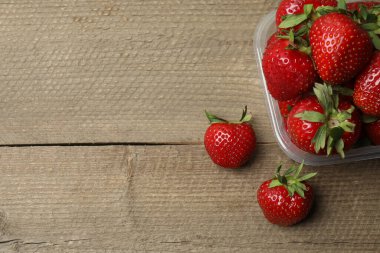 Konteynırdaki ahşap masada çilekler.