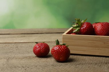 Konteynırdaki ahşap masada çilekler.