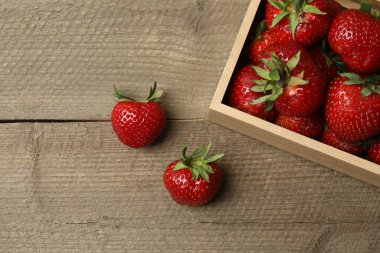 Konteynırdaki ahşap masada çilekler.