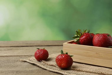 Konteynırdaki ahşap masada çilekler.