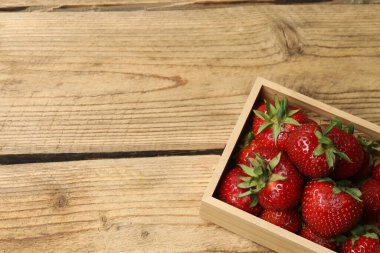 Konteynırdaki ahşap masada çilekler.