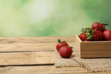 Konteynırdaki ahşap masada çilekler.