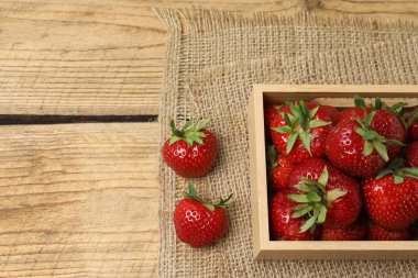 Konteynırdaki ahşap masada çilekler.