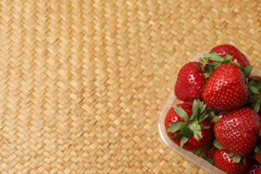 Konteynırdaki ahşap masada çilekler.