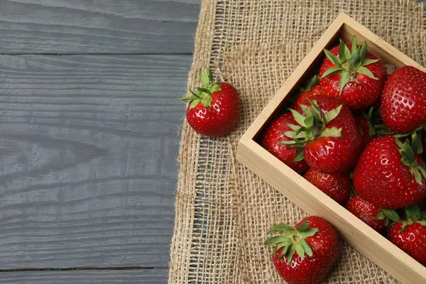 Konteynırdaki ahşap masada çilekler.