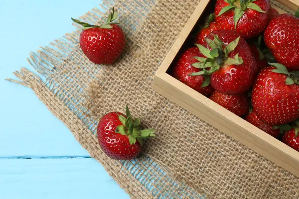 Konteynırdaki ahşap masada çilekler.