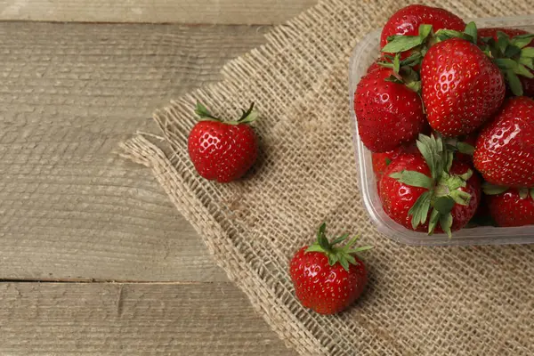 Konteynırdaki ahşap masada çilekler.