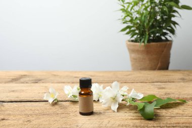Tıbbi ve kozmetik kullanım için indirme şişeleri ve ahşap masada yasemin çiçekleri. Doğal kozmetik ürünleri ve temel eko-ambalaj, spa konsepti.