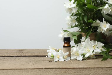Tıbbi ve kozmetik kullanım için indirme şişeleri ve ahşap masada yasemin çiçekleri. Doğal kozmetik ürünleri ve temel eko-ambalaj, spa konsepti.