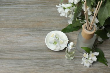 Tıbbi ve kozmetik kullanım için indirme şişeleri ve ahşap masada yasemin çiçekleri. Doğal kozmetik ürünleri ve temel eko-ambalaj, spa konsepti.
