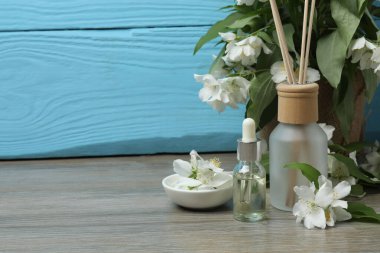 Tıbbi ve kozmetik kullanım için indirme şişeleri ve ahşap masada yasemin çiçekleri. Doğal kozmetik ürünleri ve temel eko-ambalaj, spa konsepti.