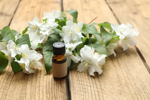 Tıbbi ve kozmetik kullanım için indirme şişeleri ve ahşap masada yasemin çiçekleri. Doğal kozmetik ürünleri ve temel eko-ambalaj, spa konsepti.