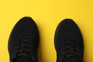 Sarı arka planda spor ayakkabılar, üst manzara