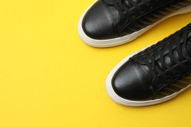 Sarı arka planda spor ayakkabılar, üst manzara