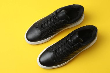 Sarı arka planda spor ayakkabılar, üst manzara