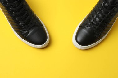 Sarı arka planda spor ayakkabılar, üst manzara
