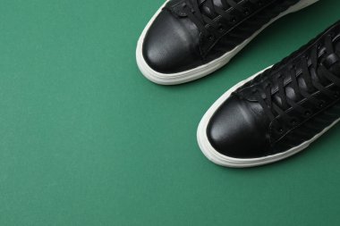 Yeşil arka planda spor ayakkabılar, üst görünüm
