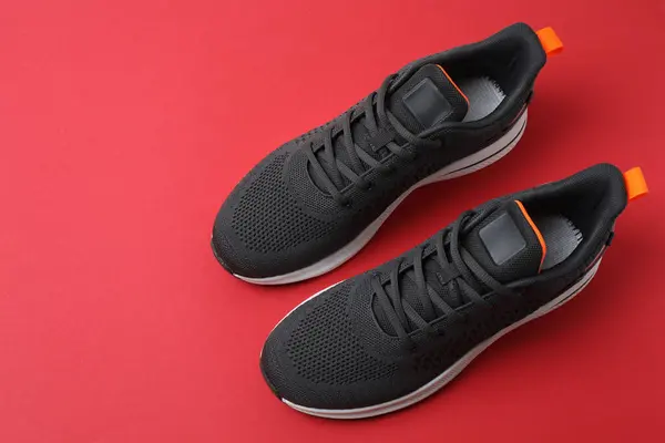 Kırmızı arka planda spor ayakkabıları, üst görünüm