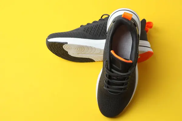 Sarı arka planda spor ayakkabılar, üst manzara