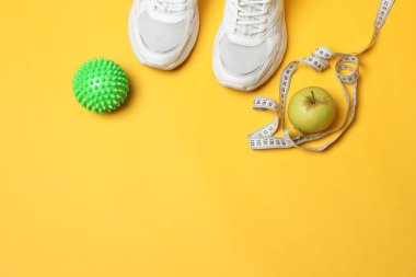 Sarı arka planda spor aletleri seti, üst manzara.