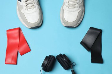 Mavi arka planda spor ekipmanları seti, üst görünüm