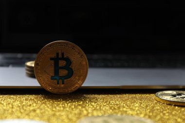 Bilgisayarın arka planında Bitcoin, altın para, kripto para. Demir