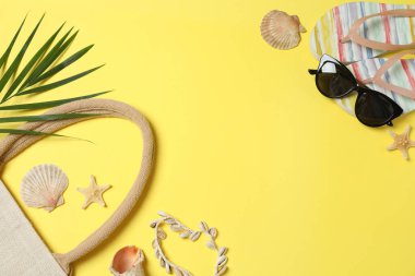 Yukarıdan gelen tropik titreşimler. Hasır şapka, güneş gözlüğü, ananas, hasır çanta, sarı arka planda plaj aksesuarları. Reklam ya da metin kaplamaları için mükemmel