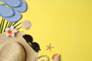 Yukarıdan gelen tropik titreşimler. Hasır şapka, güneş gözlüğü, ananas, hasır çanta, sarı arka planda plaj aksesuarları. Reklam ya da metin kaplamaları için mükemmel