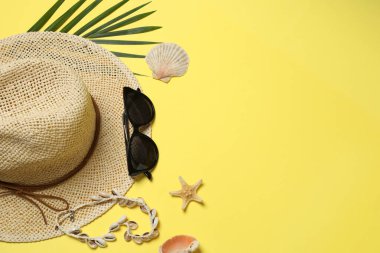 Yukarıdan gelen tropik titreşimler. Hasır şapka, güneş gözlüğü, ananas, hasır çanta, sarı arka planda plaj aksesuarları. Reklam ya da metin kaplamaları için mükemmel