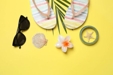 Yukarıdan gelen tropik titreşimler. Hasır şapka, güneş gözlüğü, ananas, hasır çanta, sarı arka planda plaj aksesuarları. Reklam ya da metin kaplamaları için mükemmel