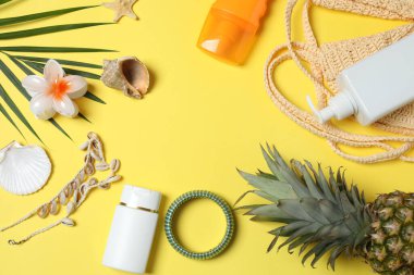 Yukarıdan gelen tropik titreşimler. Hasır şapka, güneş gözlüğü, ananas, hasır çanta, sarı arka planda plaj aksesuarları. Reklam ya da metin kaplamaları için mükemmel