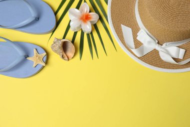 Yukarıdan gelen tropik titreşimler. Hasır şapka, güneş gözlüğü, ananas, hasır çanta, sarı arka planda plaj aksesuarları. Reklam ya da metin kaplamaları için mükemmel