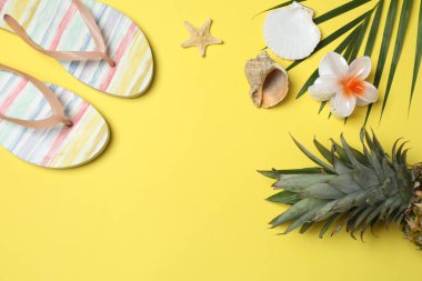 Yukarıdan gelen tropik titreşimler. Hasır şapka, güneş gözlüğü, ananas, hasır çanta, sarı arka planda plaj aksesuarları. Reklam ya da metin kaplamaları için mükemmel