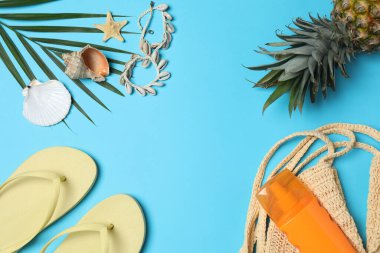 Yukarıdan gelen tropik titreşimler. Hasır şapka, güneş gözlüğü, ananas, hasır çanta, mavi arka planda plaj aksesuarları. Reklam ya da metin kaplamaları için mükemmel