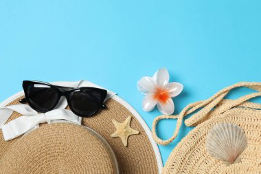 Yukarıdan gelen tropik titreşimler. Hasır şapka, güneş gözlüğü, ananas, hasır çanta, mavi arka planda plaj aksesuarları. Reklam ya da metin kaplamaları için mükemmel