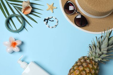 Yukarıdan gelen tropik titreşimler. Hasır şapka, güneş gözlüğü, ananas, hasır çanta, mavi arka planda plaj aksesuarları. Reklam ya da metin kaplamaları için mükemmel