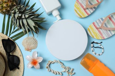 Yukarıdan gelen tropik titreşimler. Hasır şapka, güneş gözlüğü, ananas, hasır çanta, mavi arka planda plaj aksesuarları. Reklam ya da metin kaplamaları için mükemmel