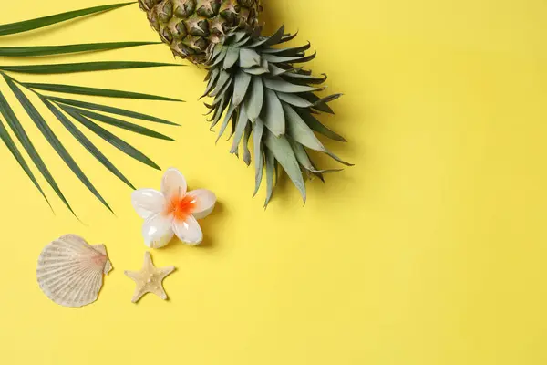 Yukarıdan gelen tropik titreşimler. Hasır şapka, güneş gözlüğü, ananas, hasır çanta, sarı arka planda plaj aksesuarları. Reklam ya da metin kaplamaları için mükemmel