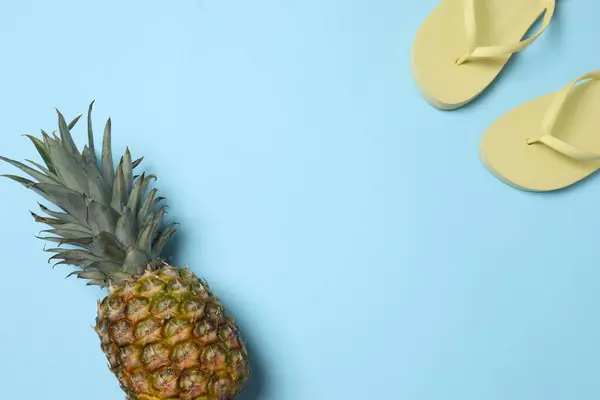 Yukarıdan gelen tropik titreşimler. Hasır şapka, güneş gözlüğü, ananas, hasır çanta, mavi arka planda plaj aksesuarları. Reklam ya da metin kaplamaları için mükemmel