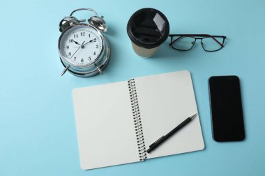 beyaz zemin üzerinde dizüstü bilgisayar, gözlük ve alarm saati ile düz konum.